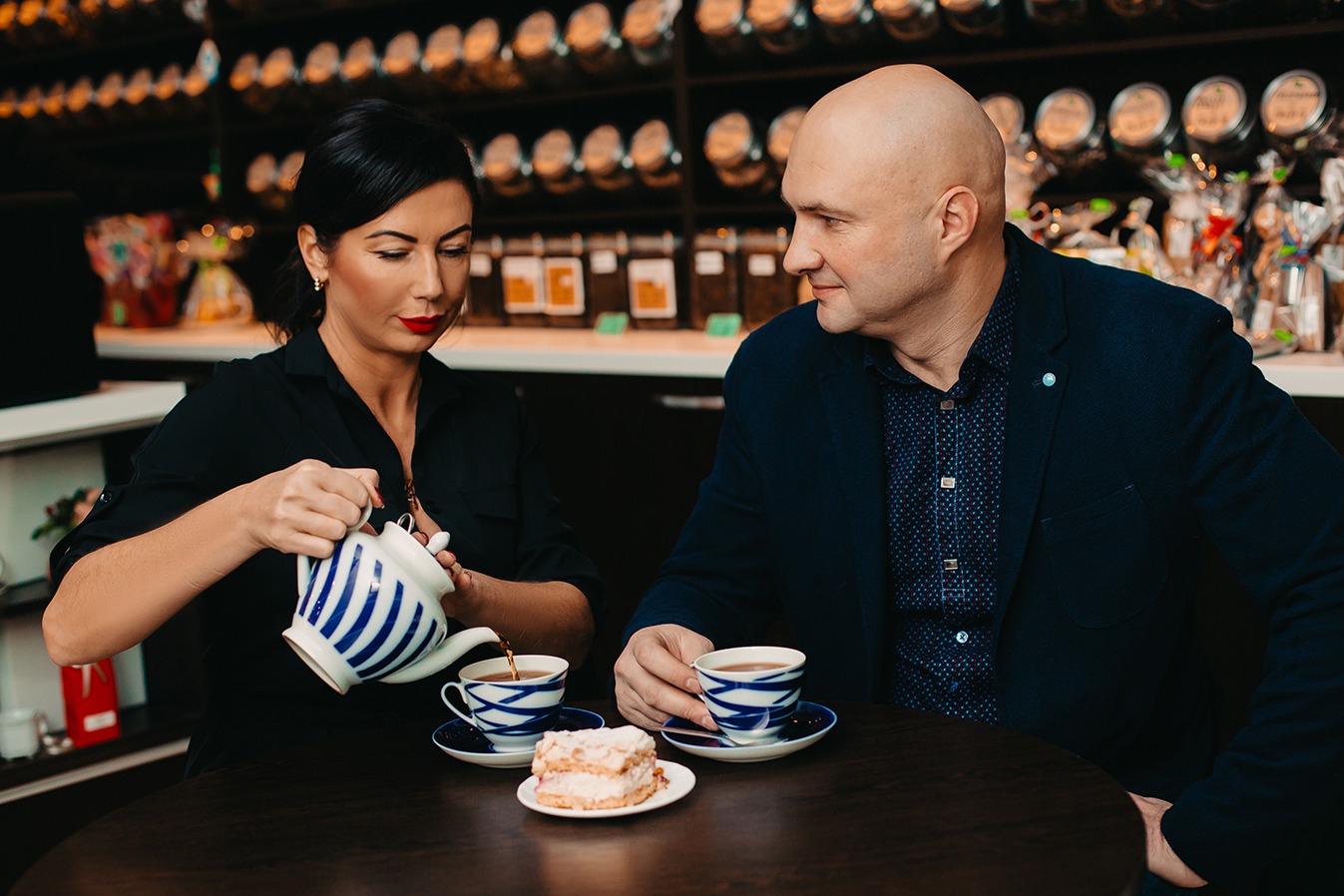 Kahe inimese teetseremoonia kohvikus - teekann ja koogitükk laual